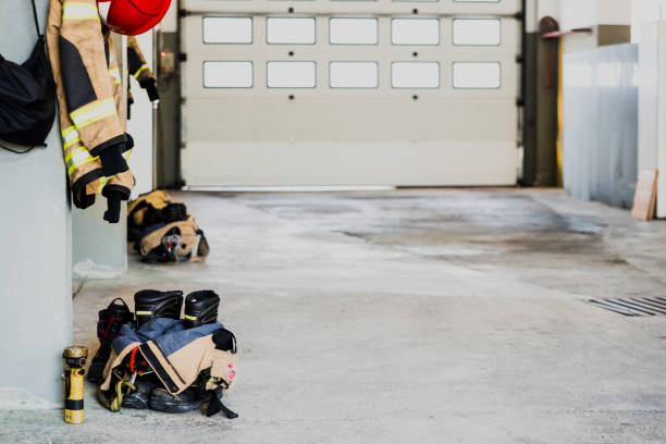 istock Boots and fireman's jacket on the garage floor of a fire station. 1713047763
