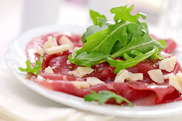 Carpaccio Carpaccio served with arugula and parmesan cheese carpaccio parmesan cheese beef raw stock pictures, royalty-free photos & images