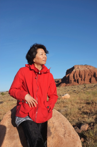 Mature Chinese businesswoman against scenic background.