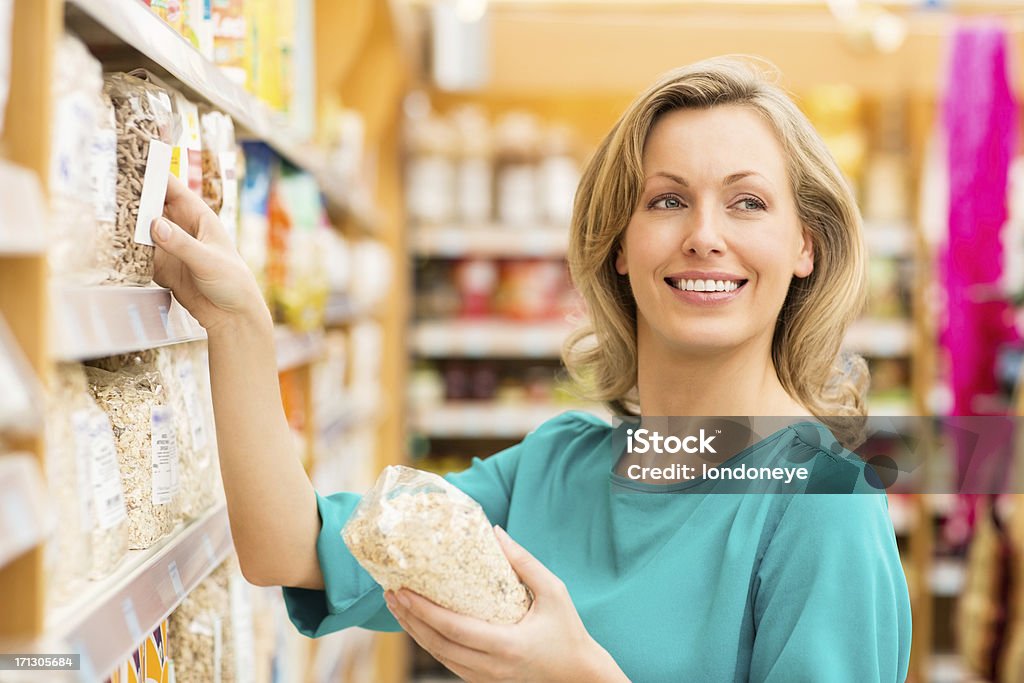 Donna shopping nel supermercato per i cereali - Foto stock royalty-free di Abbigliamento casual