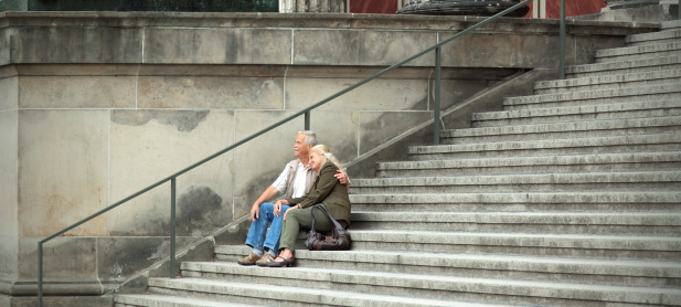 Senior couple sitting on large staircase in Berlin, Germany.