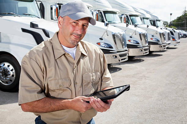 istock Truck driver in front of big rigs with digital tablet 171306293