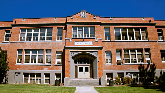 Exterior of large brick high school on a sunny day.