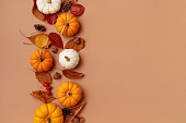 Autumn Thanksgiving holiday background from pumpkins, colorful dried leaves and fall decorations top view.