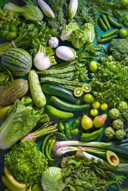 Raw fruits and vegetables vegan food on monochrome green table full frame Raw fruits and vegetables varied vegan food on monochrome green table full frame background spring mix lettuce leaves stock pictures, royalty-free photos & images