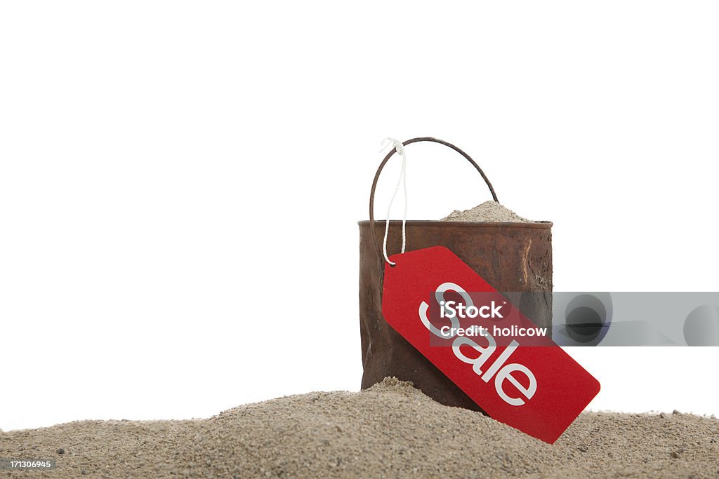 Old Inventory Rusty Can Sale "A rusty old can in the sand with a sale tag attached to the handle. Studio shot on white background, with room for copy." Beach Stock Photo