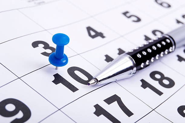 Blue Pin on Calendar with Pen stock photo