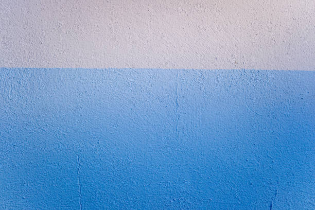 istock Blue and white bicolor background of a textured wall illuminated laterally by sunlight. 1713073739