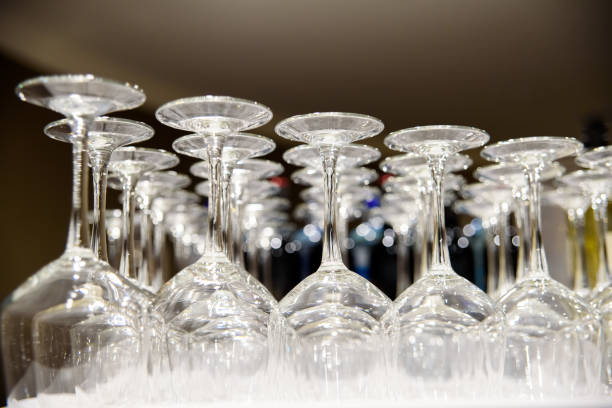 istock Empty wine glasses stacked on a barman's table, illuminated at night, for a party. 1713076985