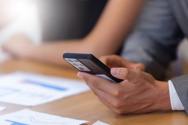 istock Close up selective focus at Smartphone in hand of businessman at table office. Using mobile phone to work online. 1713084138