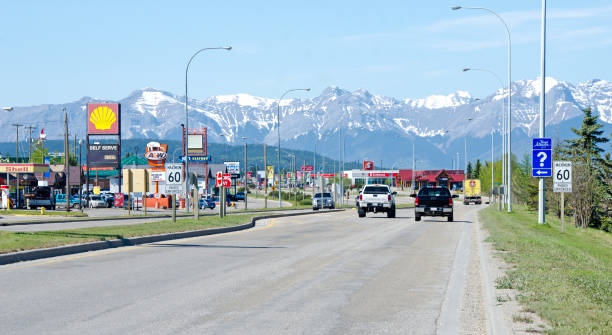 Hinton and Yellowhead Highway "Edson, Canada - May 27, 2012:  In the town of Hinton the main road and highway through the town  with retail shops and service buildings. The Rocky Mountains are in the distance.  Hinton is on the Yellowhead Highway between Jasper and Edmonton." hinton alberta stock pictures, royalty-free photos & images