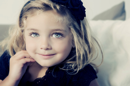 Cute girl portrait on a white background with copy space. 5 years old girl wearing white dress