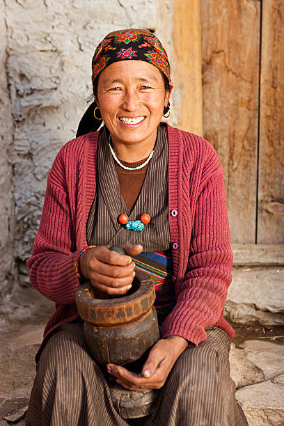istock Tibetan woman using a mortar to make  flour. Mustang, Nepal 171309295