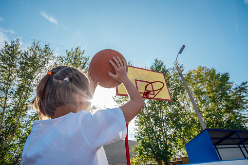 Courage in the Twilight: Girl's Resilience Radiates in Outdoor Basketball Match
