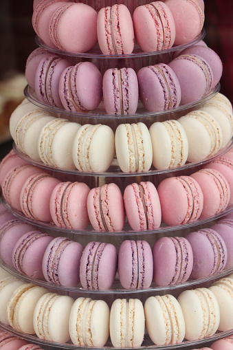 Tower of macarons in white, purple and pink, often seen at the dessert table at a wedding