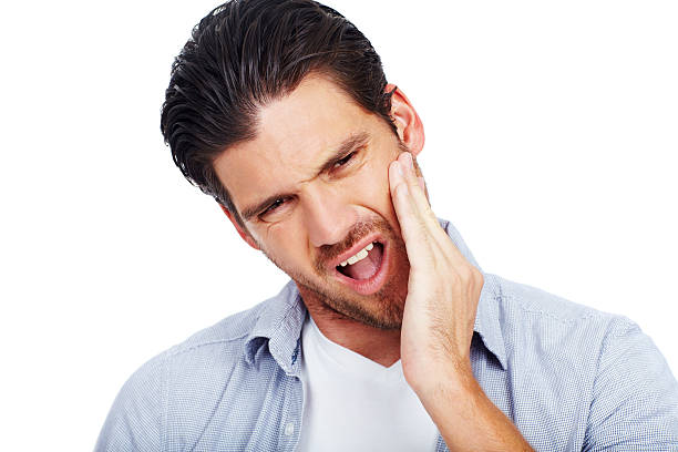 Man with painful expression holding one cheek