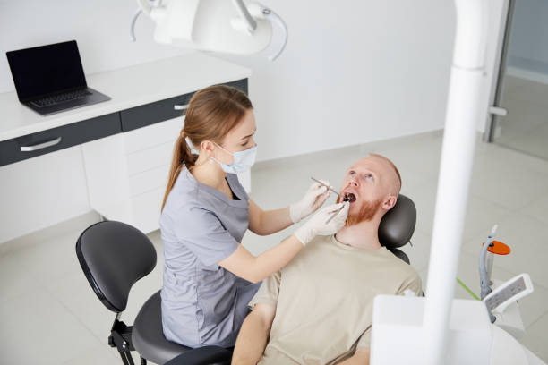 retrato de una joven dentista de pie junto a un hombre adulto en la clínica. dentista hembra reparando diente de paciente en ambulant dental - ambulant patient fotografías e imágenes de stock