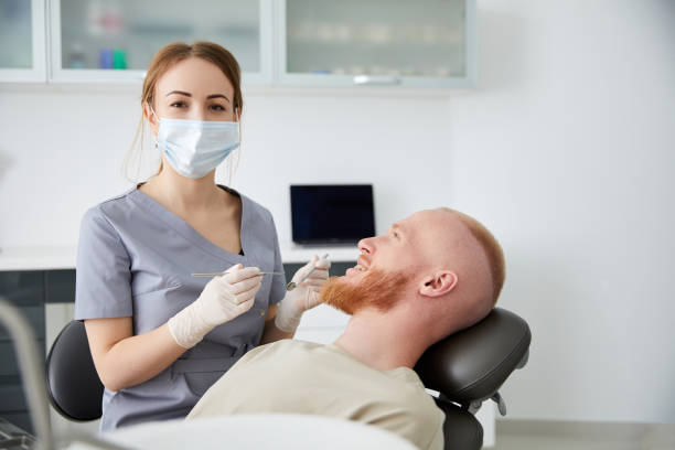 retrato de una joven dentista de pie junto a un hombre adulto en la clínica. dentista hembra reparando diente de paciente en ambulant dental - ambulant patient fotografías e imágenes de stock