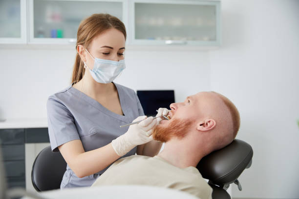 retrato de una joven dentista de pie junto a un hombre adulto en la clínica. dentista hembra reparando diente de paciente en ambulant dental - ambulant patient fotografías e imágenes de stock