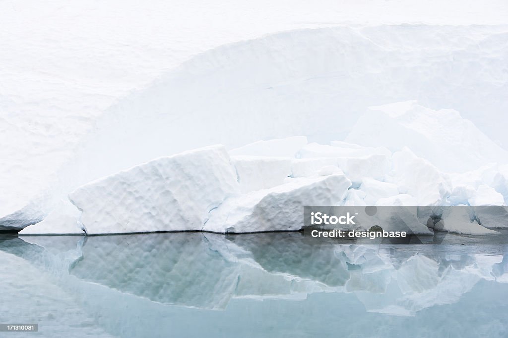 Cool Ice Reflection "Crumbs of clean ice crumnling away from the edge of a bank of snow into cool, still water" Cold Temperature Stock Photo