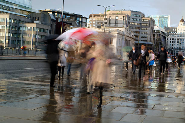 istock Commuters in the rain walking with umbrellas 171310346