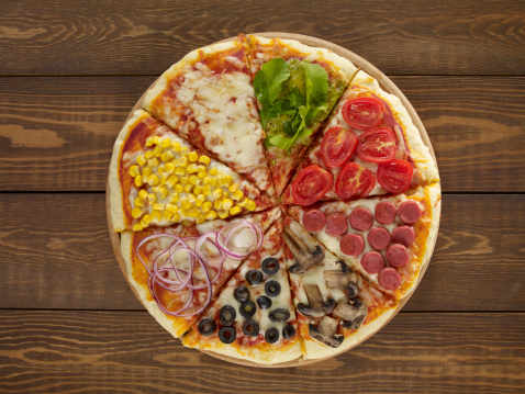 Mixed pizza on wooden background.