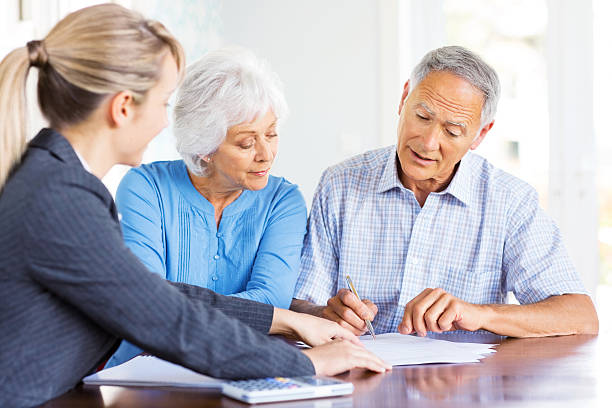 Financial Advisor Explaining Investment Plans To Senior Couple. stock photo