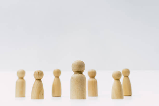 istock Small group of separated people seen from above represented anonymous with wooden figures on white background. 1713109297