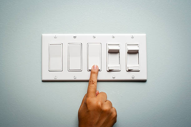 mano de mujer giro a la salida de la luz - switch fotografías e imágenes de stock