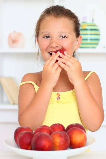 istock Little girl bite peach 171311782
