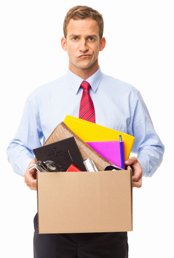 Portrait of young male executive carrying cardboard box with personal items. Vertical shot. Isolated on white.