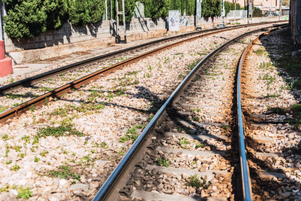 istock Two curved train tracks in a turn within a village 1713126115
