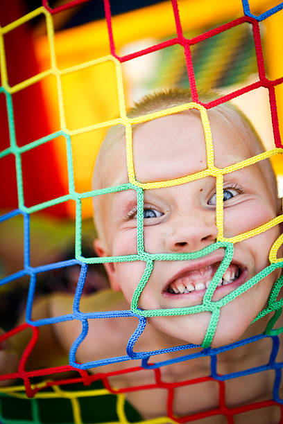 Feliz menino em bounce casa em uma festa de verão - foto de acervo