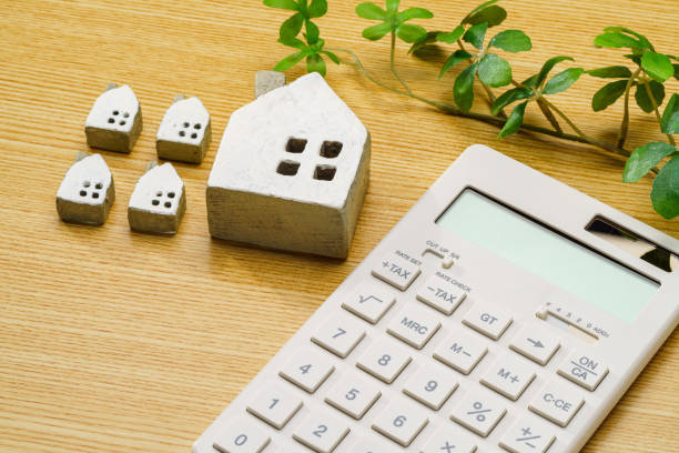 istock Calculator and miniature house on wooden table 1713135227