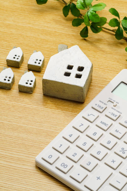 istock Calculator and miniature house on wooden table 1713135739