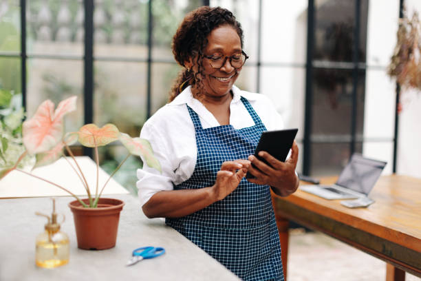 istock Happy female florist using a tablet to manage her small business 1713135754