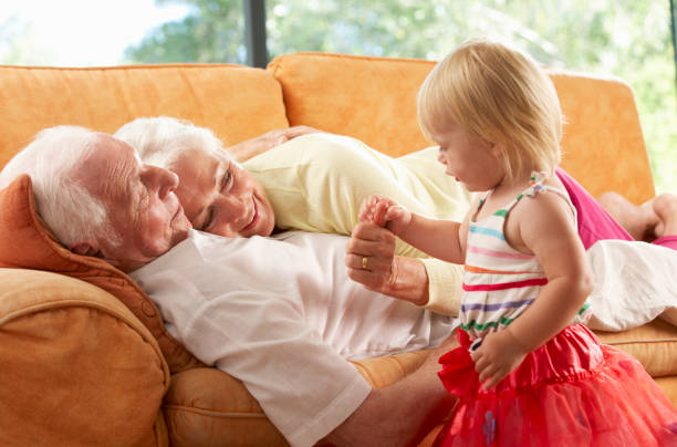istock Senior Couple Lying On Sofa With Granddaughter 171313755