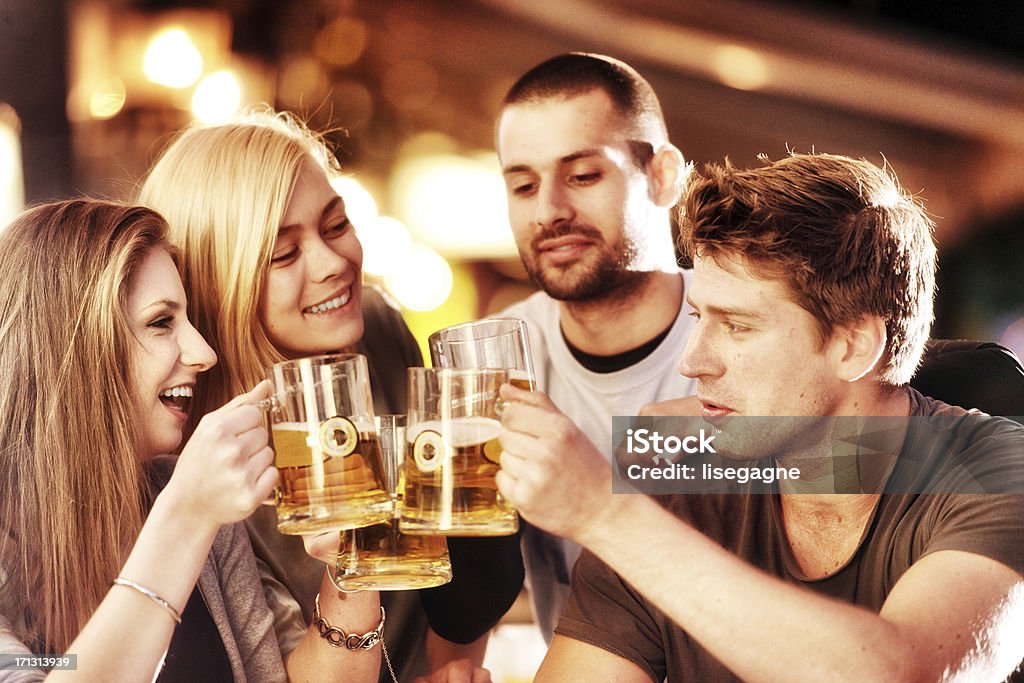 Young group of people having fun on a sidewalk bar "Young group of people having fun on a sidewalk bar.  Note the label of the beer has been totally redesigned by myself. Istockalypse Berlin, 2012" 20-24 Years Stock Photo