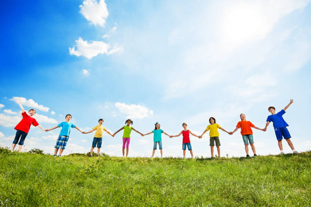 istock Group of kids holding hands against the sky. 171314064