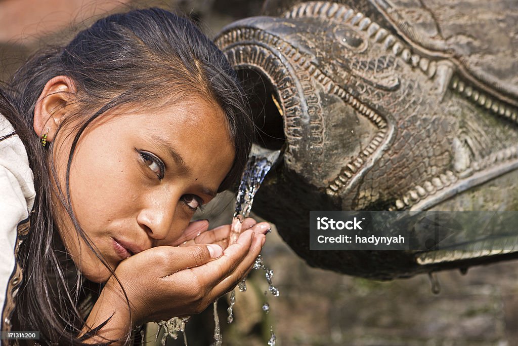 Nepalese giovane ragazza Bere dalla fontana della città sulla piazza del Durbar - Foto stock royalty-free di 8-9 anni