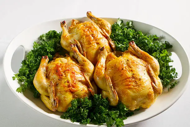 Three cornish game hens roasted to perfection and nestled in garden fresh parsley.