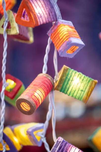 A string of lights with small colorful paper lanterns shining in different colors