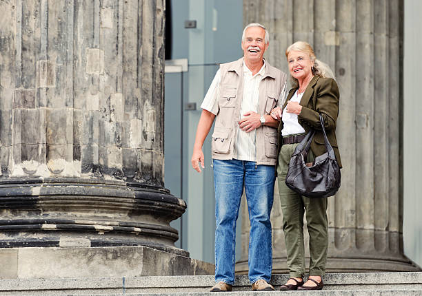 A caucasian senior couple on the edge of stairs. Copy space on left.