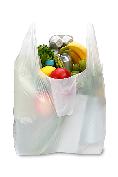 A white plastic grocery bag filled with produce White plastic grocery bag isolated on white/clipping path plastic bag stock pictures, royalty-free photos & images