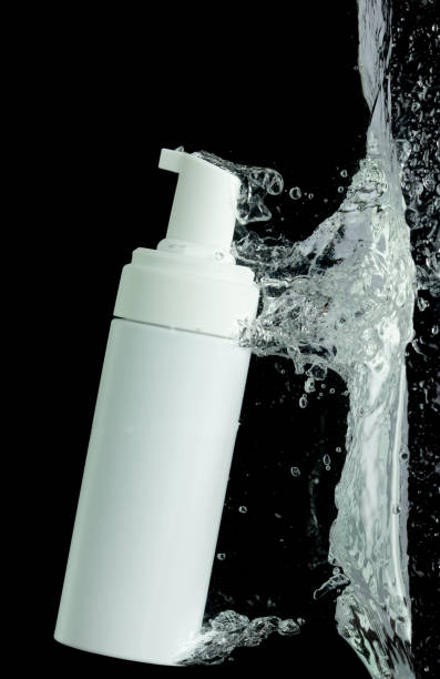 istock Cosmetic container fall into clear water with air bubble. Pump cosmetic treatment container drop to clear water of freshness. Black background isolated freeze element 1713158525