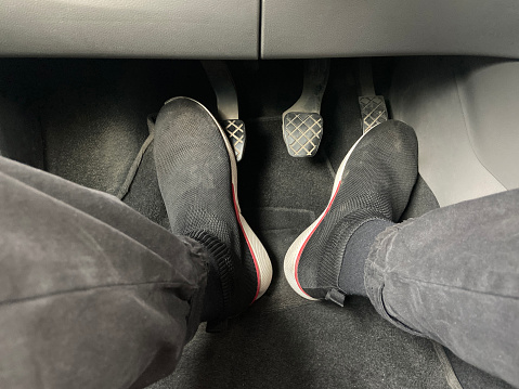 Driver foots on car pedals