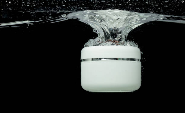 istock Cosmetic container fall into clear water with air bubble. Small cosmetic treatment container drop to clear water of freshness. Black background isolated freeze element 1713159058