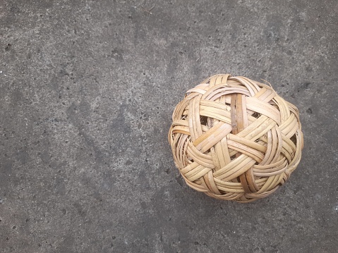 takraw ball made of rattan top view with street texture background. background concept of sport, tradition, games, match, play, lifestyle, championship, victory, fair play, player