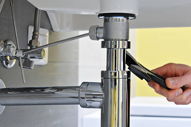 Close-up of plumber's hand doing repairing work at the sink stock photo