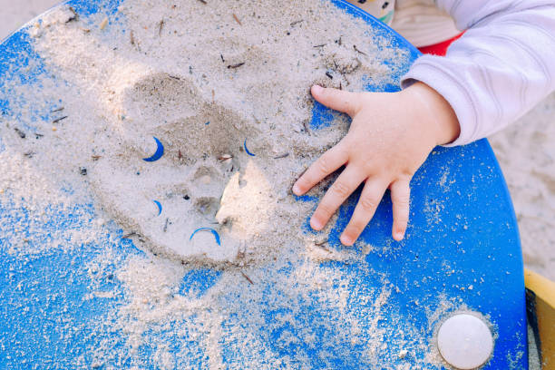 Child's Hands Holding Sand on Sunny Beach. Summer Concept Close-up